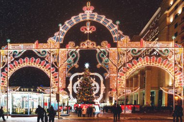 Moskova, Rusya - 11 Ocak 2017. Noel ve yeni yıl kutlama için dekore edilmiş Moskova tarihi merkezinde yürüyüş insanlar. Kışın karlı akşam.