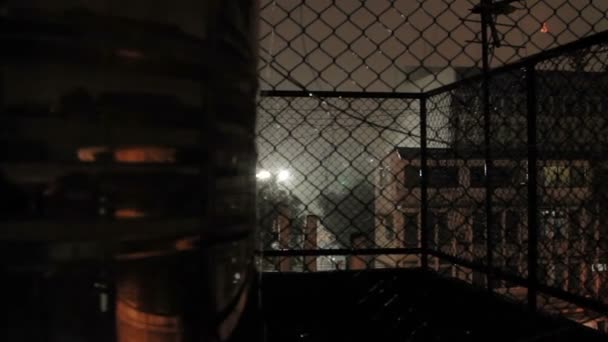 La lluvia nocturna en Bangkok. Vista sobre calle mojada desde balcón a través de rabitz net. Tailandia . — Vídeo de stock