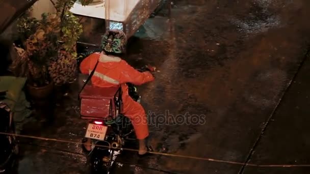 Bangkok, Tayland - 25 Ekim 2012. Adam bir motosiklet sürüş. Akşam şiddetli yağmur. — Stok video