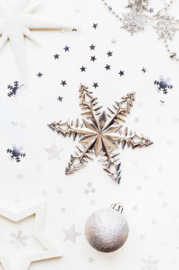 Noel ve yılbaşı tatil arka plan dekorasyon ve ampuller ile. Gümüş ve beyaz toplar, beyaz kar taneleri ve yıldız konfeti parlayan. Düz yatıyordu, en iyi görünümü.