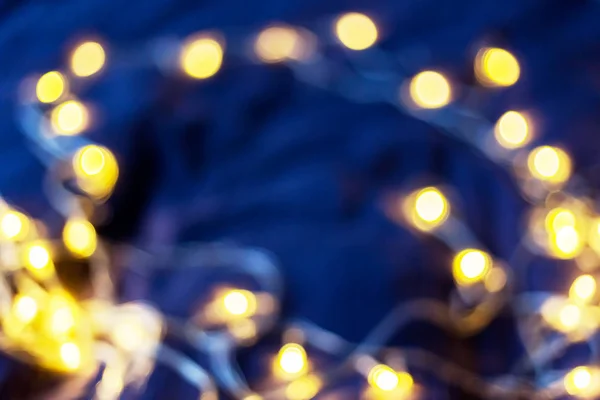 Defocused nacht straatverlichting, wazig kleurrijke bokeh achtergrond. Vakantie kleurrijke lantaarns en gloeilampen slingers. — Stockfoto