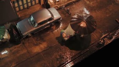 Bangkok, Tayland - 25 Ekim 2012. Şiddetli yağmur akşam. Şemsiye ile yürüyen insanlar ve gıda sepeti.