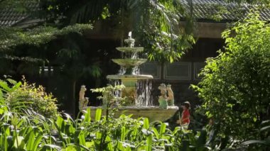 Bangkok, Tayland - 25 Ekim 2012. Kadın firures ile çeşme suyu boşaltır. Park güneşli bir günde.