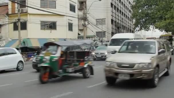 БАНГКОК, ТАИЛАНД - 25 октября 2012 года. Движение на одной из улиц Бангкока. Перевозка автомобилей, мотоциклов, туктуков, автобусов . — стоковое видео