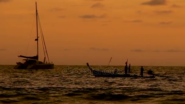 Ηλιοβασίλεμα στην παραλία Naiharn. Ομάδα ανθρώπων σε βάρκα περνά. Cloudscape σε πορτοκαλί φόντο ηλιοβασίλεμα. — Αρχείο Βίντεο