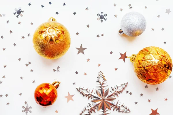 Noël et Nouvel An fond de vacances avec des décorations et des ampoules. Boules brillantes en argent et or, flocons de neige et confettis étoilés. Couché plat, vue du dessus . — Photo