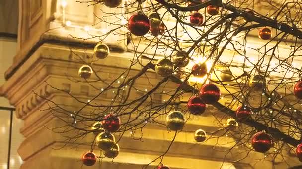 Calles de Moscú decoradas para la celebración de Año Nuevo y Navidad. Árbol con bolas de color rojo brillante y amarillo. GUM Tienda Principal con bombillas en el fondo. Rusia . — Vídeos de Stock