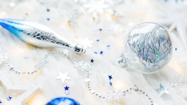 Fondo de Navidad y Año Nuevo con decoraciones y bombillas. Bolas brillantes plateadas y azules, copos de nieve y confeti estrella . —  Fotos de Stock