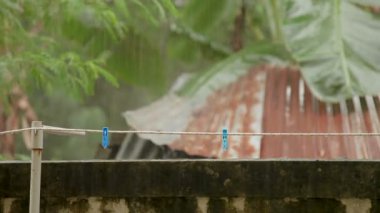 Ağır yağmur altında clothespins ile ip. Phuket Island, Tayland.