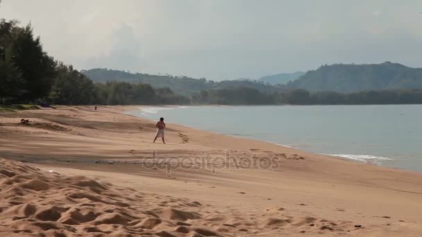 PHUKET, THAILANDIA - 25 novembre 2012. Bambino che cammina nel mare surf. Giornata di sole sull'isola di Phuket, Thailandia . — Video Stock