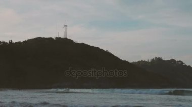 Nai Harn Beach gün batımı. Rüzgar Türbini tepe üzerinde görüntüleyin. Phuket, Tayland.