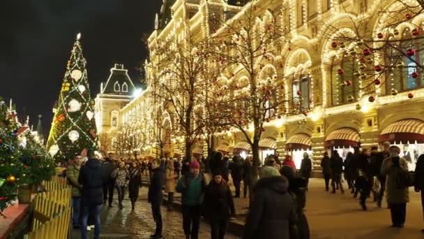 MOSCÚ, RUSIA - 03 de diciembre de 2017: Gente en el mercado de Navidad cerca de los grandes almacenes en la Plaza Roja. Edificios y árboles decorados e iluminados para la celebración de Año Nuevo . — Vídeos de Stock