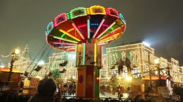 MOSCOW, RÚSSIA - 03 de dezembro de 2017: Carrossel colorido iluminado na feira de Natal na Praça Vermelha. Edifícios e árvores decorados para a celebração do Ano Novo . — Vídeo de Stock