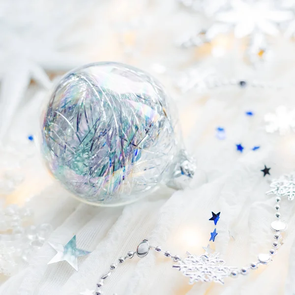 Noël et Nouvel An fond de vacances avec des décorations et des ampoules. Boules brillantes argentées et bleues, flocons de neige et confettis étoiles . — Photo