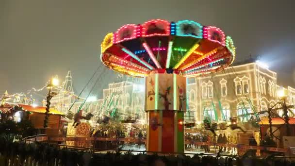 MOSCOW, RÚSSIA - 03 de dezembro de 2017: Carrossel colorido iluminado na feira de Natal na Praça Vermelha. Edifícios e árvores decorados para a celebração do Ano Novo . — Vídeo de Stock