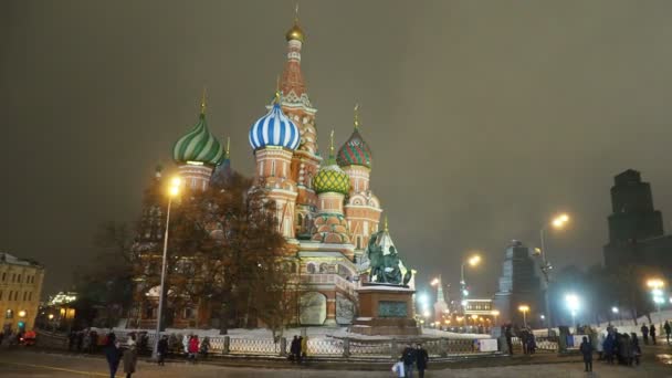 MOSCÚ, RUSIA - 14 de diciembre de 2017. Noche de invierno nevada. Gente caminando cerca de Catedral de San Basilio . — Vídeos de Stock