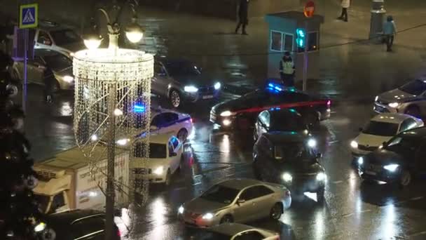 MOSCOW, RÚSSIA - 14 de dezembro de 2017. Noite de inverno nevado. Carro da comissão de investigação com escolta policial movendo-se através do tráfego na rua Nikolskaya . — Vídeo de Stock