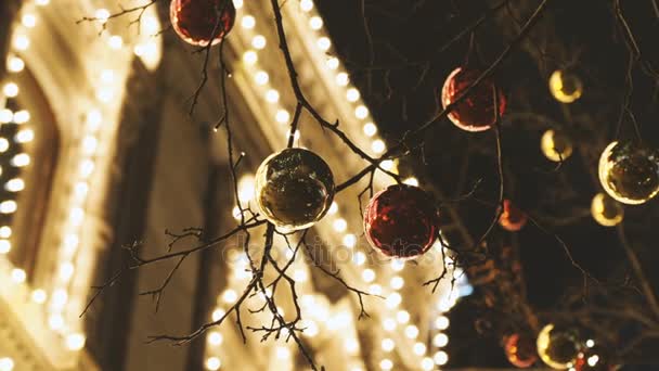 Calles de Moscú decoradas para la celebración de Año Nuevo y Navidad. Árbol con bolas de color rojo brillante y amarillo. GUM Tienda Principal con bombillas en el fondo. Rusia . — Vídeos de Stock