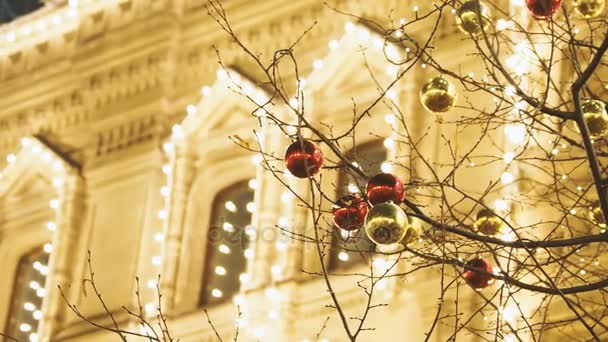 新年とクリスマスのお祝いのためにモスクワの通りが飾られています。明るい赤と黄色のボールと木。ガムの背景に電球とグム百貨店。ロシア. — ストック動画