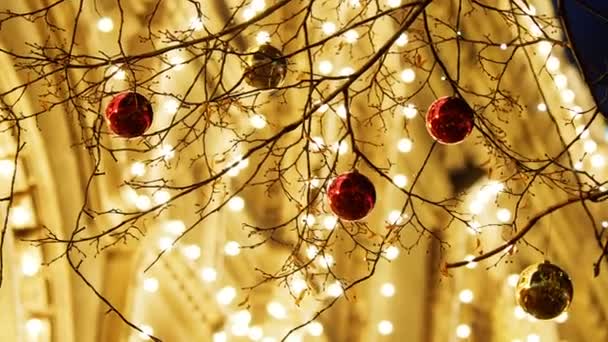 Calles de Moscú decoradas para la celebración de Año Nuevo y Navidad. Árbol con bolas de color rojo brillante y amarillo. GUM Tienda Principal con bombillas en el fondo. Rusia . — Vídeos de Stock