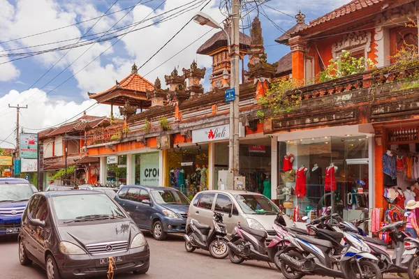 UBUD, INDONESIA - 31 de enero de 2013. Coches de mudanza pasar tiendas de recuerdos y boutiques de ropa . — Foto de Stock