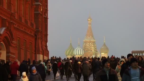 Moskau, russland - 14. Dezember 2017. Menschen gehen auf dem Roten Platz am Staatlichen Historischen Museum vorbei. Blick auf die Basilikumkathedrale. — Stockvideo