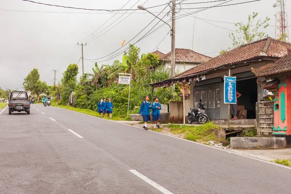 BALI, INDONESIA - 30 de enero de 2013. La vida callejera habitual en Bali. Estudiantes y alumnos se van a casa después de la escuela . — Foto de Stock