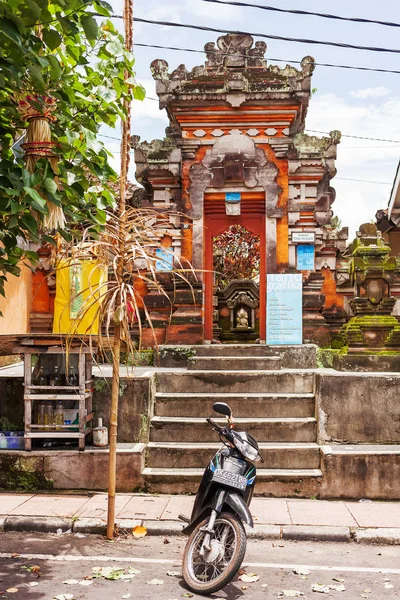 UBUD, INDONESIA - 31 de enero de 2013. Moto aparcado cerca del edificio. Arquitectura balinesa tradicional, entrada con puerta decorativa . — Foto de Stock