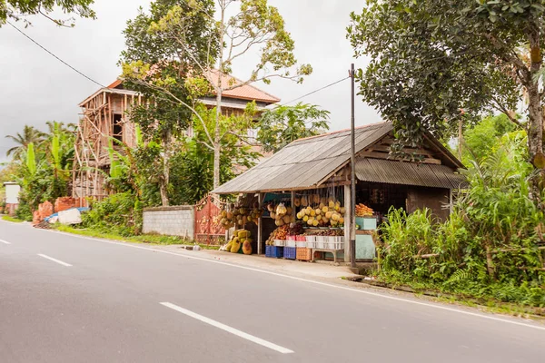 Tienda de frutas callejera. Pequeña tienda al aire libre con durians, plátanos, mangostanes. Bali, Indonesia . — Foto de Stock