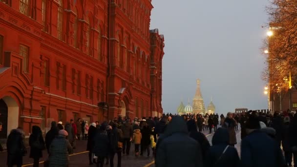 Moskva, Ryssland - 14 December 2017. Människor som gick på Röda torget passerar Statens historiska Museum. Utsikt över St Basil Cathedral. — Stockvideo