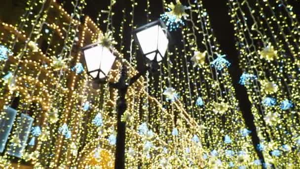 Nikolskaya rue décorée pour la célébration de Noël et du Nouvel An. Vue du bas sur les ampoules décoratives, imitation pluie dorée. Moscou, Russie . — Video