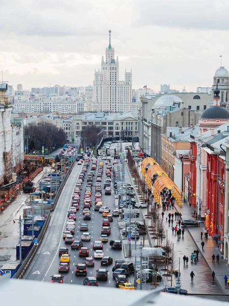 Voitures se déplaçant sur la rue Novaya ploschad décoré pour la célébration du Nouvel An. Vue sur Kotelnicheskaya Embankment Building, l'un des sept gratte-ciel staliniens. Moscou, Russie . — Photo