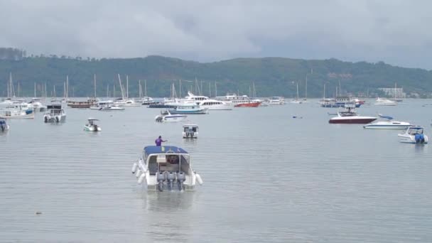Phuket, Tajlandia - listopad 24, 2012. Łodzie i jachty zakotwiczone w przystani Chalong. Motorówka pływa dalej na otwartym morzu. — Wideo stockowe