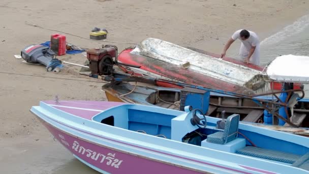 Phuket, Thailand - 24 November 2012. Man rengöra sin båt, remowing ogräs med spateln verktyg. Piren i Chalong. — Stockvideo