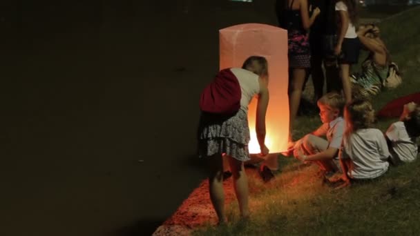 PHUKET, TAILANDIA - 28 de noviembre de 2012. Locales y turistas celebrando Loi Krathong. La gente bajó a las coronas de agua con velas y soltó las linternas chinas del papel del cielo . — Vídeos de Stock