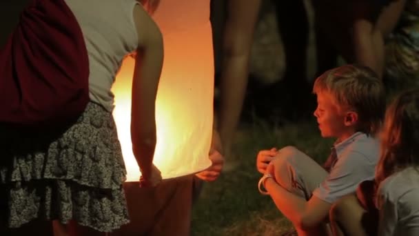 Phuket, Thaiföld - November 28, 2012. Helyiek és a turisták ünnepli a Loi Krathong. Emberek leeresztette a víz koszorúk gyertyákkal, és engedje, hogy ég kínai papír lampion. — Stock videók