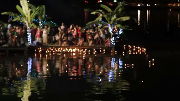 Phuket, Thailand - November 28, 2012. Lokalbefolkning och turister firar Loi Krathong. Människor sänks ned i de vatten kransar med ljus och låt gå till himlen kinesiska papperslyktor. — Stockvideo