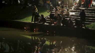 Phuket, Tayland - 28 Kasım 2012. Yerli halk ve turistler Loi Krathong kutluyor. İnsanlar içine su çelenk mumlar ile indirdi ve cennet Çin kağıt fenerler için bırak.