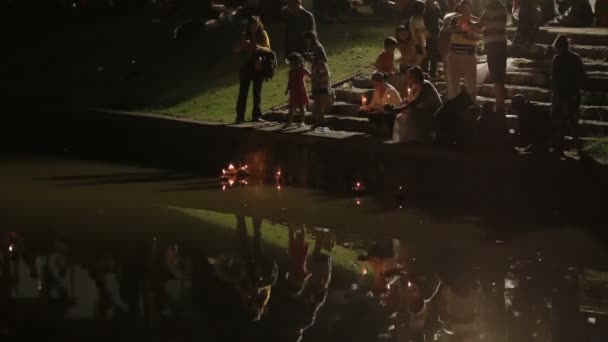 Phuket, Thailand - November 28, 2012. Lokalbefolkning och turister firar Loi Krathong. Människor sänks ned i de vatten kransar med ljus och låt gå till himlen kinesiska papperslyktor. — Stockvideo