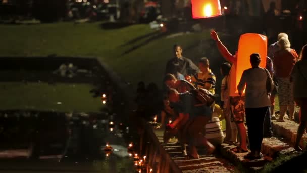 PHUKET, THAILAND - 28 November 2012. Penduduk setempat dan wisatawan merayakan Loi Krathong. Orang-orang menurunkan ke dalam karangan bunga air dengan lilin dan membiarkan pergi ke surga lentera kertas Cina . — Stok Video