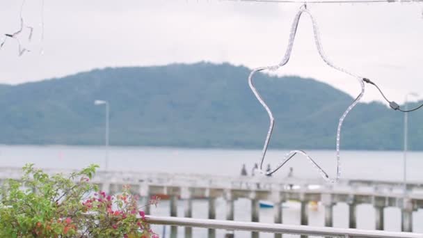 Avstängd stjärnigt gjord av glödlampor. Visa på Chalong Pier efter regn. Phuket, Thailand. — Stockvideo