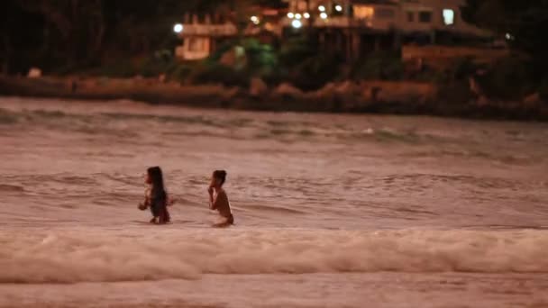 PATTAYA, TAILANDIA - 29 de octubre de 2012. Puesta de sol en la playa. Niños nadando en el mar surf . — Vídeo de stock