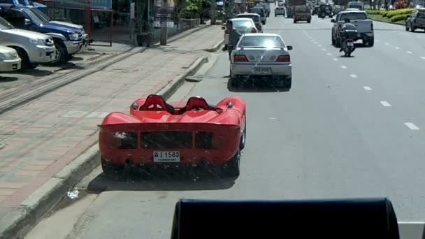 バンコク, タイ王国 - 2012 年 10 月 25 日。移動バスのフロントの窓からバンコクの通り。ファッショナブルな赤いスポーツカー. — ストック動画