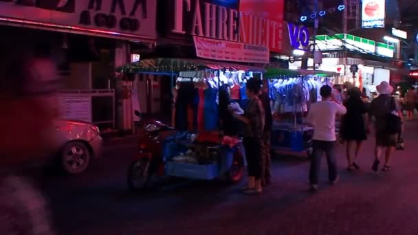 BANGKOK, TAILANDIA - 20 de octubre de 2012. Vida nocturna en la carretera Sukhumvit. Bicicletas Tuktuk con venta de ropa. Carteles publicitarios iluminados, multitud de lugareños y turistas . — Vídeos de Stock