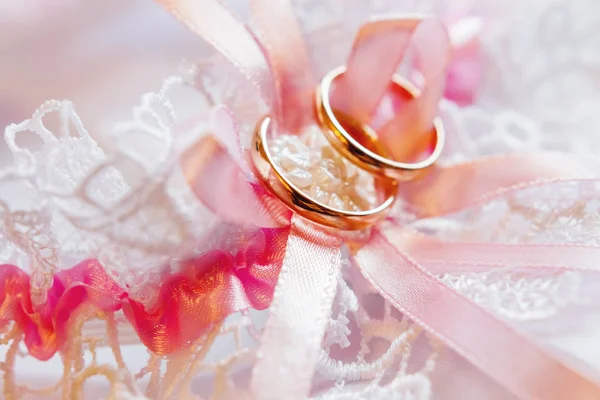 Par de anillos de boda dorados en tela de encaje. detalle vestido de bordado de boda . — Foto de Stock