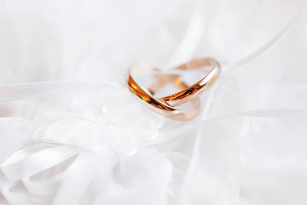 Par de anillos de boda dorados en tela de seda de encaje con flor de tela. detalle vestido de bordado de boda . — Foto de Stock