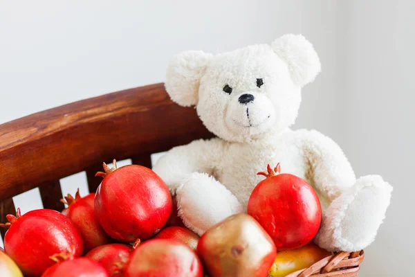 Interior details - fake pomegranates, shabby chic style wooden chair and plush toy bear. Stock Image