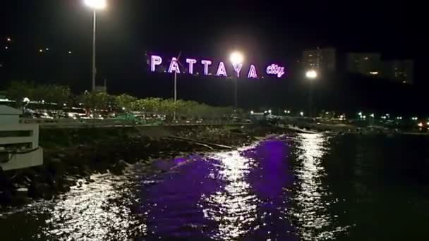 Visa på havsstranden på natten. Hav surfa nära vallen med belysta ord Pattaya city. Thailand. — Stockvideo