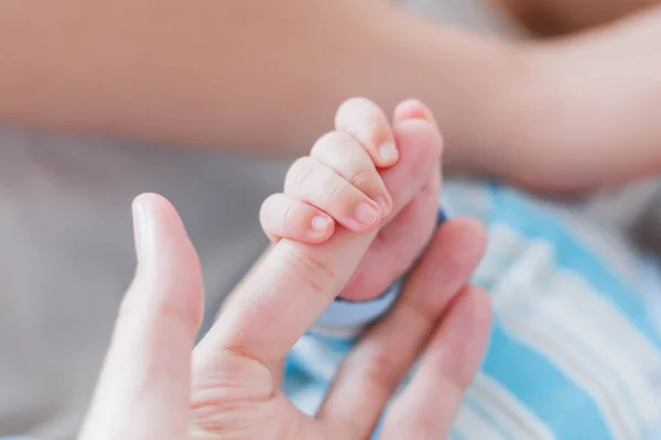 Nyfödda barnet håller hans mor finger. Händerna på små barn och vuxen kvinna. Ögonblick av ömhet. — Stockfoto