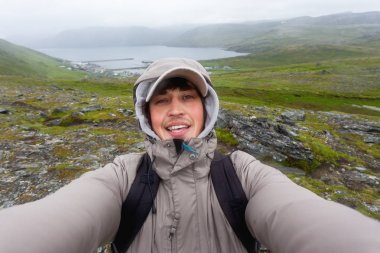 Selfie Skarsvag (yakın Nordkapp) yakınlarındaki tepe üzerinde yapma turist adam. Lofoten Adaları dönüm noktası. Norveç.